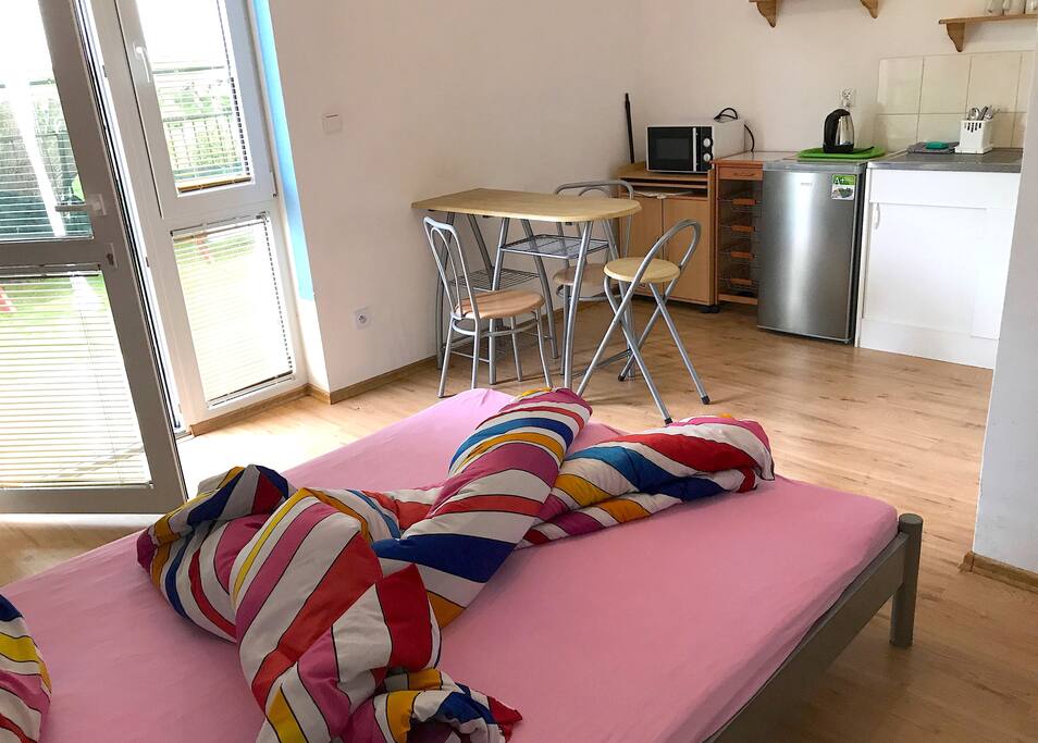 Geschirr und Besteck, Kühlschrank und ein Wasserkocher befinden sich im Zimmer.