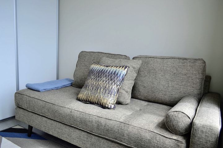 URBN-21: our second bedroom serves as a tv / living room. It features a couch that can be used as a small single bed, a coffee table, a smart tv, a full closet and blackout shades.
