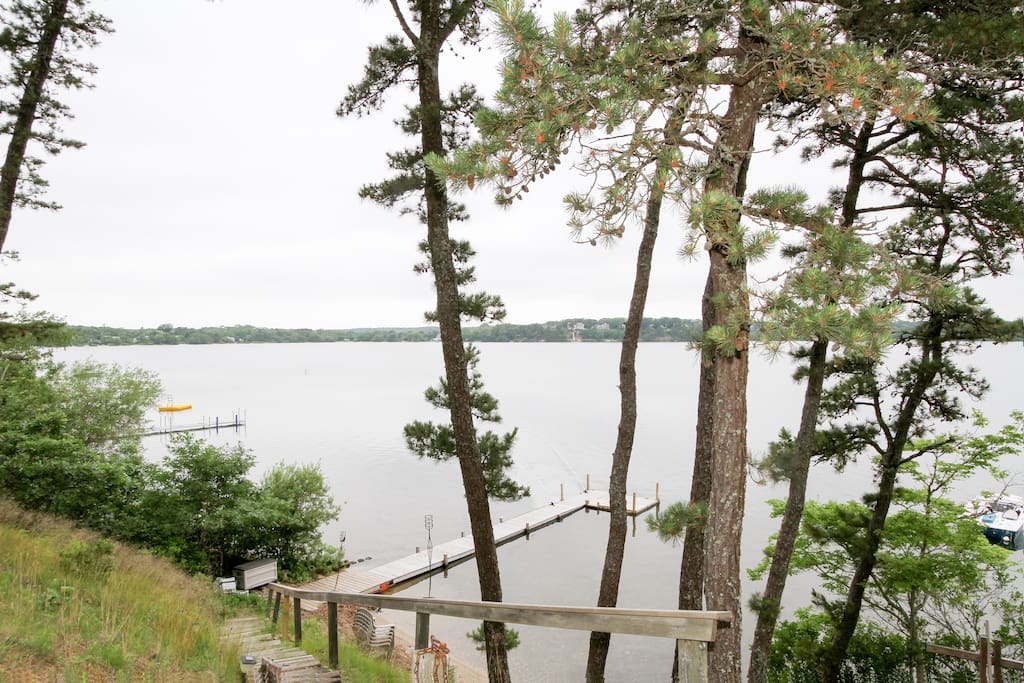 Just steps away, this exclusive home features a private beach and dock on Long Pond.