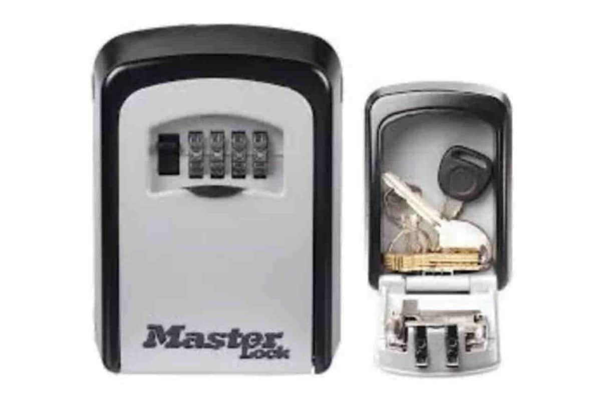 A Master Lock key box is displayed, featuring a four-digit combination keypad for secure access. The box is shown in an open position, revealing a key and a small stash of gold coins inside. The sturdy metal construction of the lockbox is highlighted.