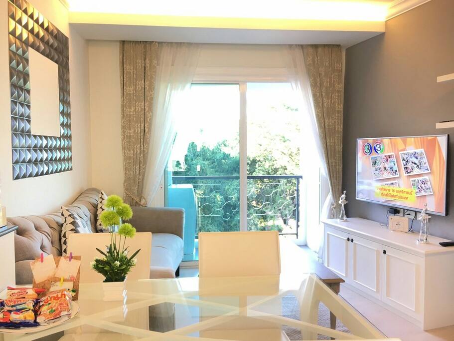 Very comfortable living room and a big tv screen. The view at the balcony is green spot down there is a small river.