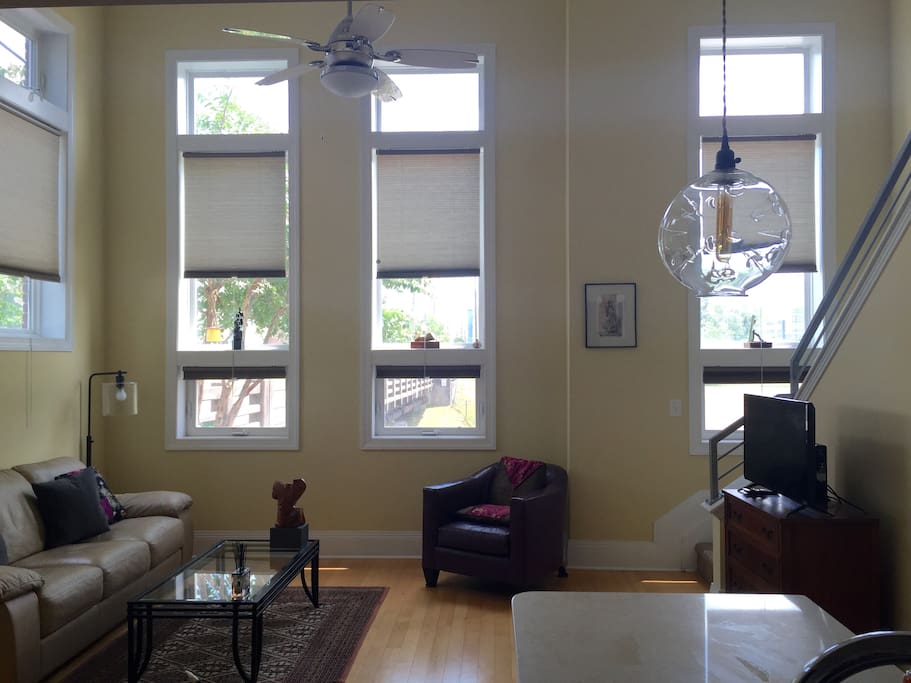 Big tall windos. Comfortable living room. Watch the world go by outside your windows, or not! Full window curtains.