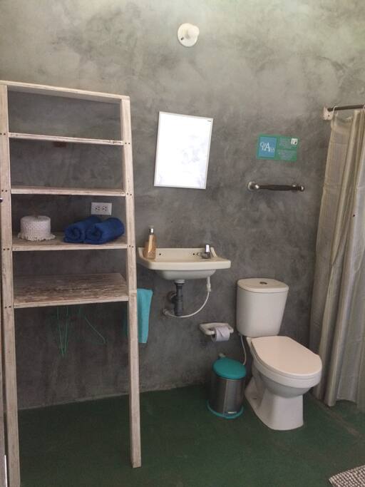 Spacious bathroom with a shower, toilet paper, towels, soap