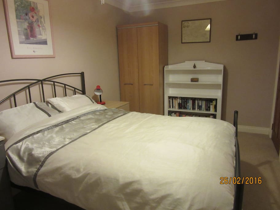 Bedroom includes wardrobe, drawers and bookcase with books to borrow