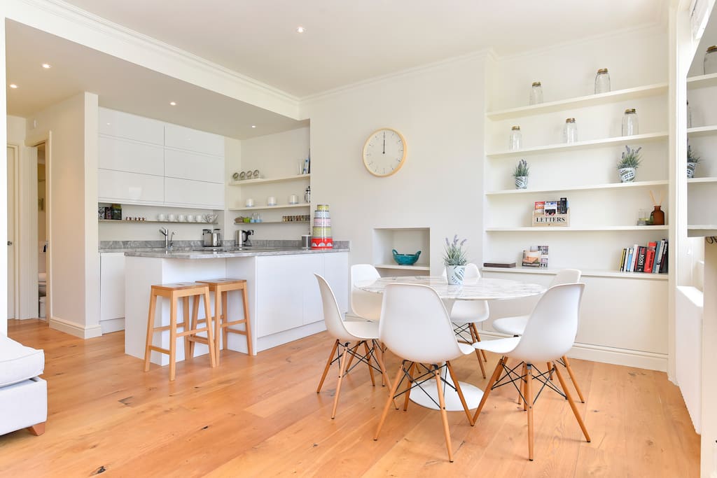 The open plan dinning/living/kitchen area is bright light and spacious. It has a table and breakfast bar.