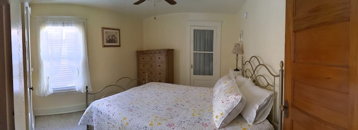 Chumba cha manjano kinajumuisha kabati kubwa la kuingia na kitanda cha malkia.  