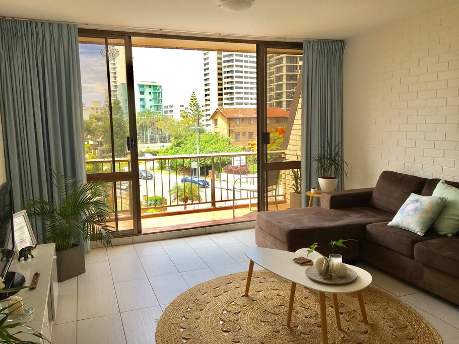 Spacious and bright living room with connecting balcony that overlooks pool with ocean views