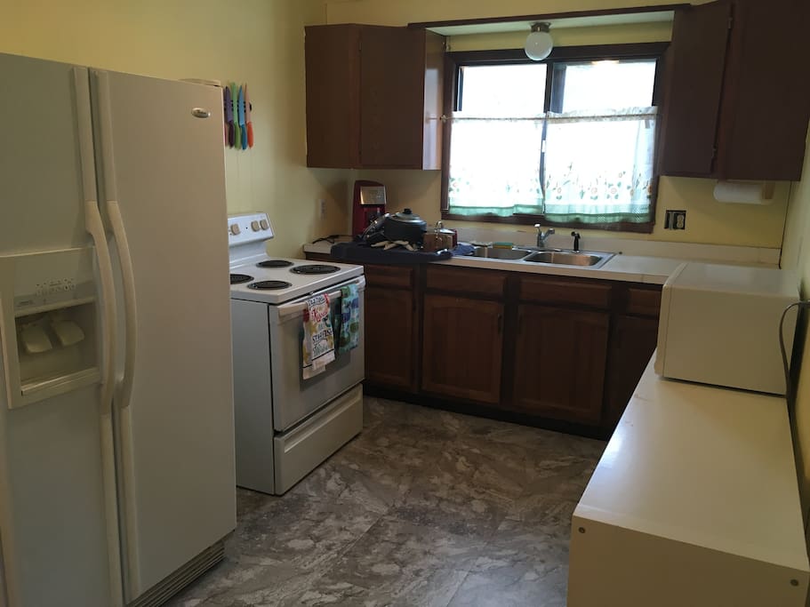 Kitchen with new flooring, fridge, microwave, stove, & coffeemaker