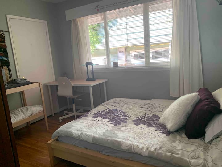 ห้องนอนพร้อมเตียงควีนไซส์และโต๊ะทำงาน