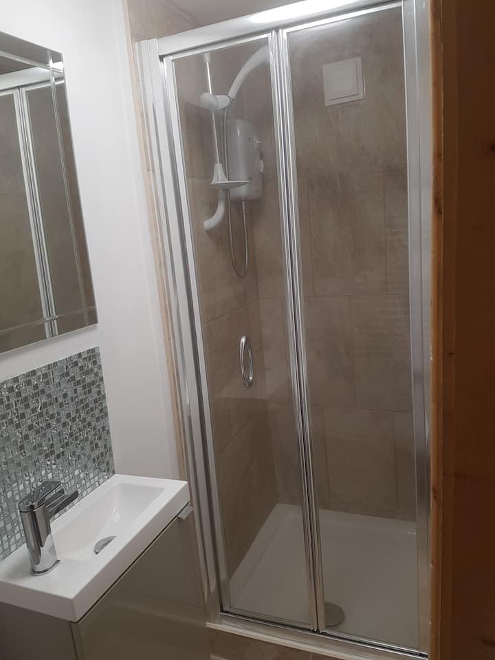 Enjoy a beautiful shower in this modern yet compact,  tiled shower/bathroom space.  