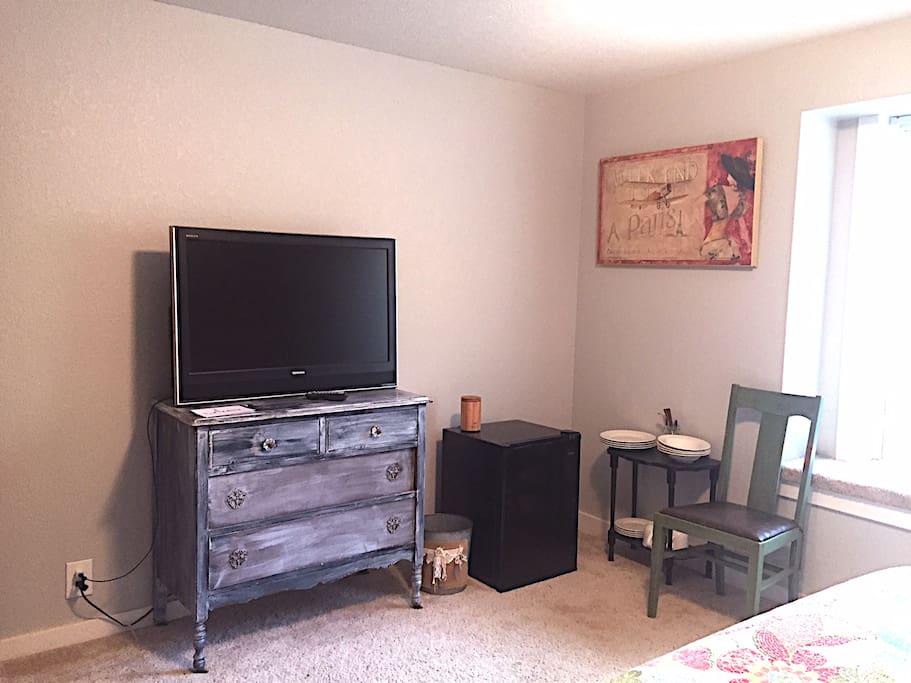 TV with Chromecast, mini fridge, and dishware