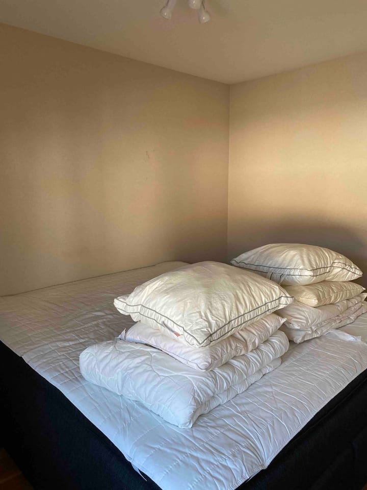 Dormitorio. Cama tamaño king tamaño king con dos lagos y almohadas. Ropa de cama no incluida.