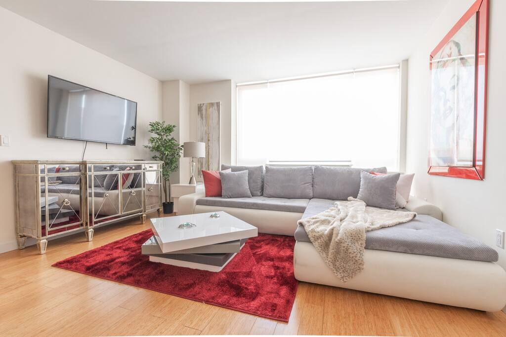 Spacious living room, a large comfortable couch and floor to ceiling windows