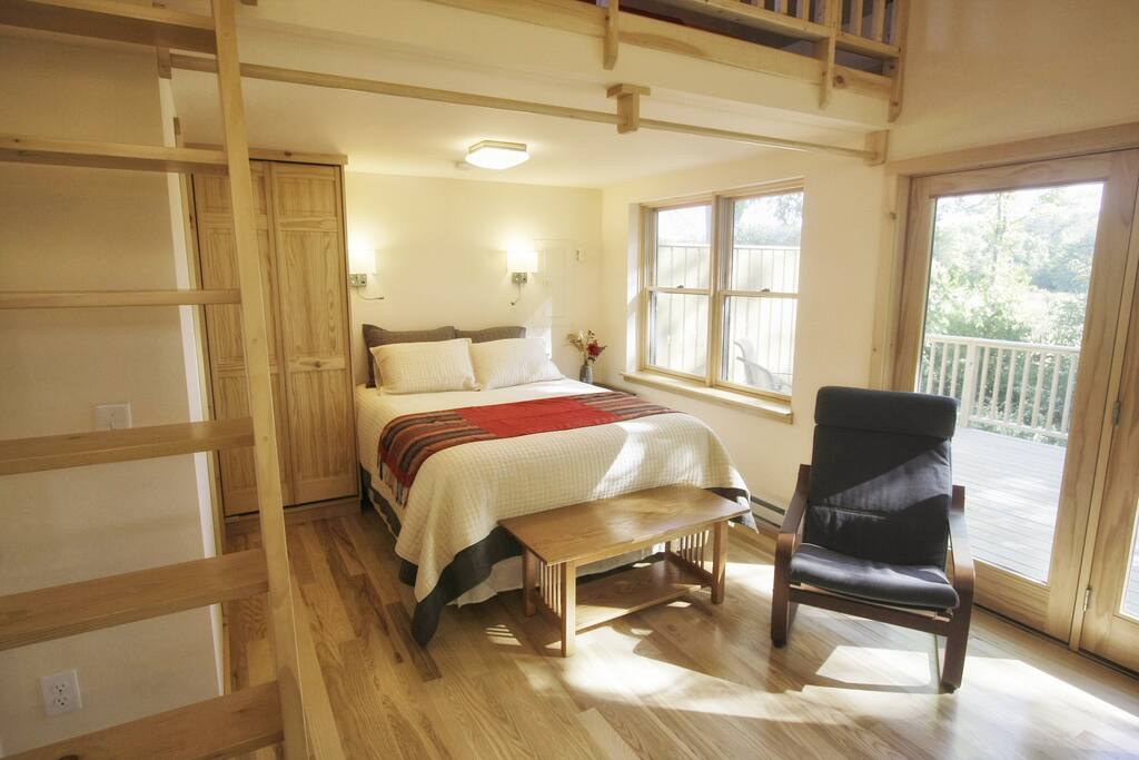 Luxurious queen bed is nestled under the loft area, with closet and bathroom to the left.