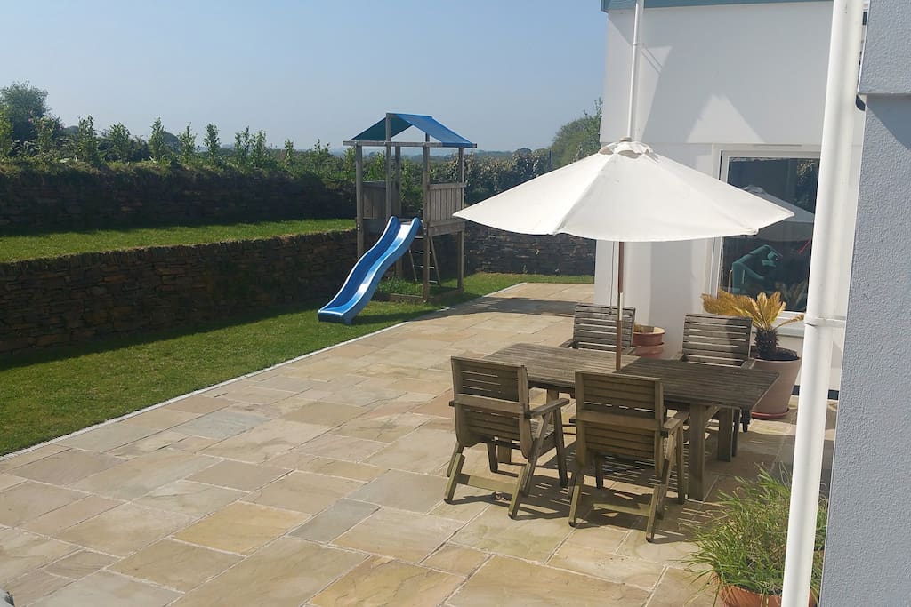 South facing garden with sunny patio, table and chairs.