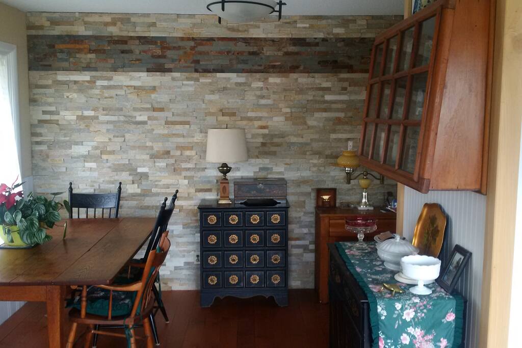 Dining area adjacent to living with lovely stone wall