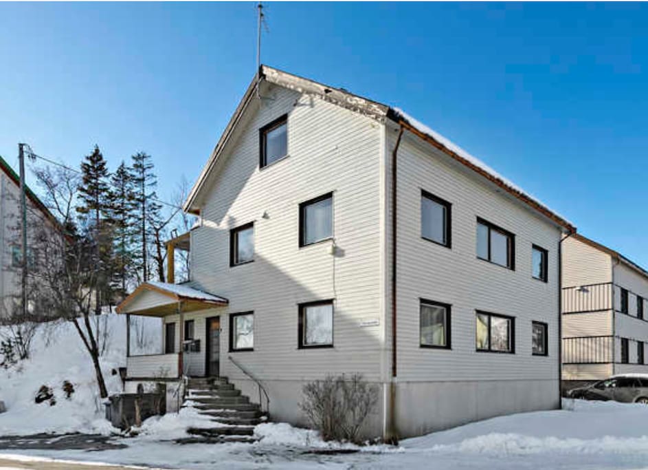 Huset sett fra veien. Inngang til leiligheten.