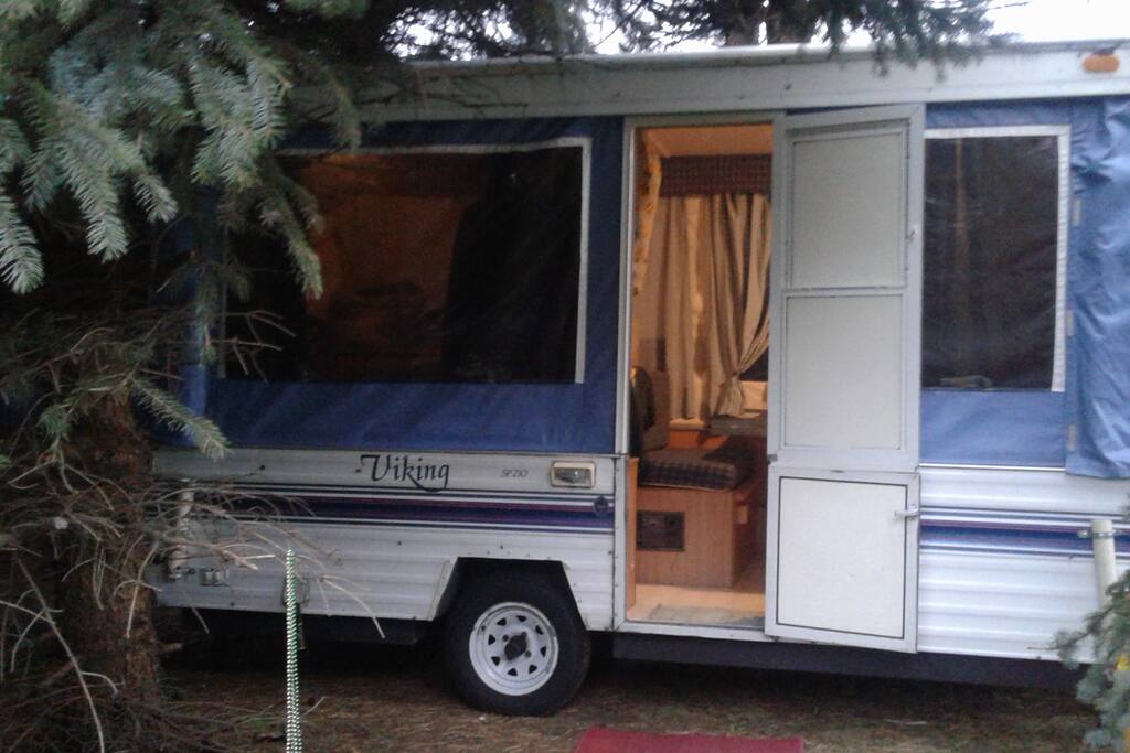 The camper with lights on, curtains open