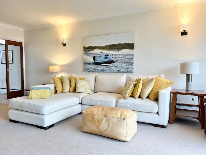 Ფართო მისაღები ოთახი გადაჰყურებს მინის აივანს, საიდანაც იშლება ხედები ბაღზე Oulton Broad-ზე.
