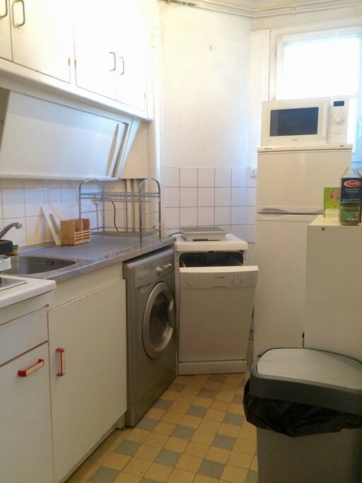 Cuisine avec lave-vaisselle et machine-à-laver séchante.