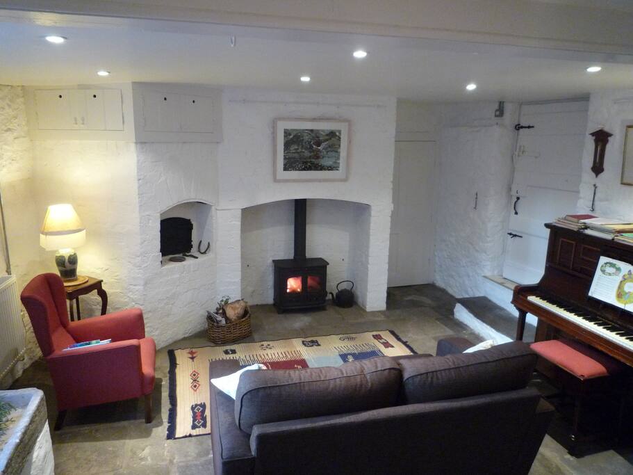 The parlour facing the wood burner, with piano