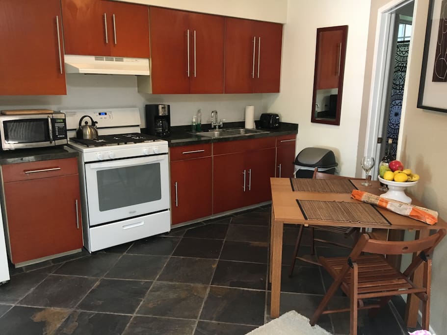 Full kitchen with dishes, cookware, bakeware, stove, oven and microwave