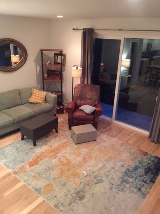 Spacious living room with comfy couch, recliner, TV and a back patio.