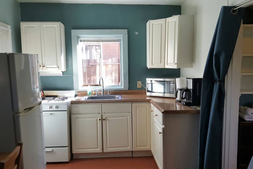 Bright kitchen complete with pots pans, coffee and coffee pot, toaster