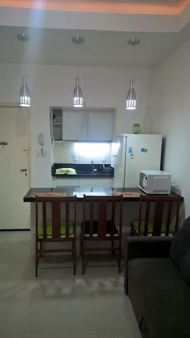 Vista da sala integrada a cozinha tipo americana, totalmente equipada.