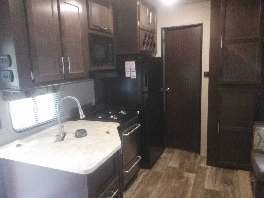 the kitchen with a full size fridge and propane stove