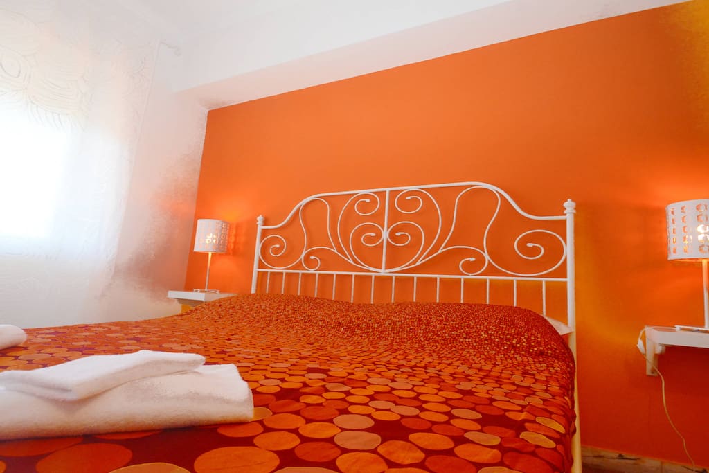 Wide orange double room with 1 double bed and 1 bunk bed