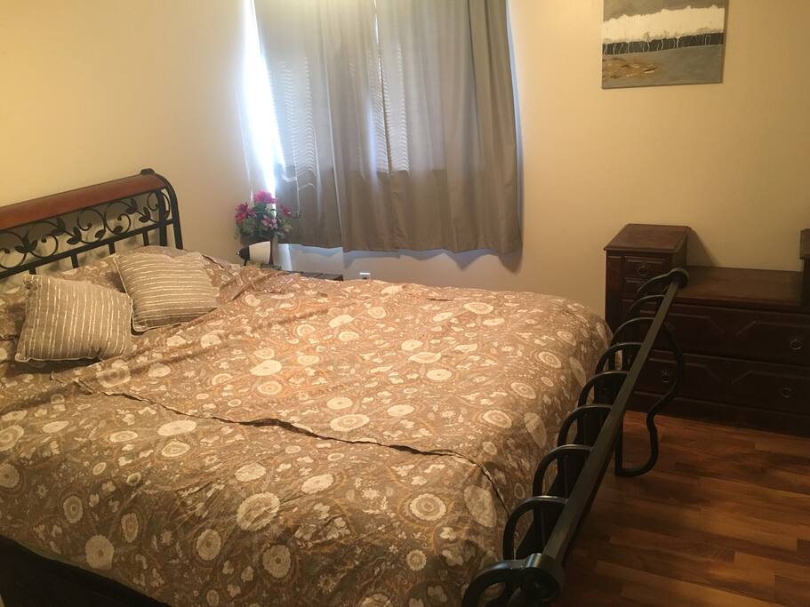 Spacious guest room with queen-size bed. To the right of this room is an identical size space with queen-size bed. There is also a pull out couch in our upstairs living room if there are more than 4 people traveling! ***The private 4-piece bathroom is located on the bottom floor of our home.***