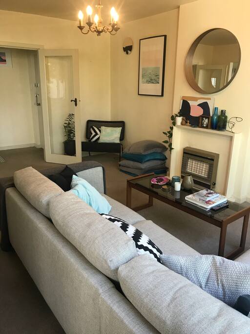Shared living room, view from balcony door. French doors open to hallway, with the kitchen on the opposite side of the hall.