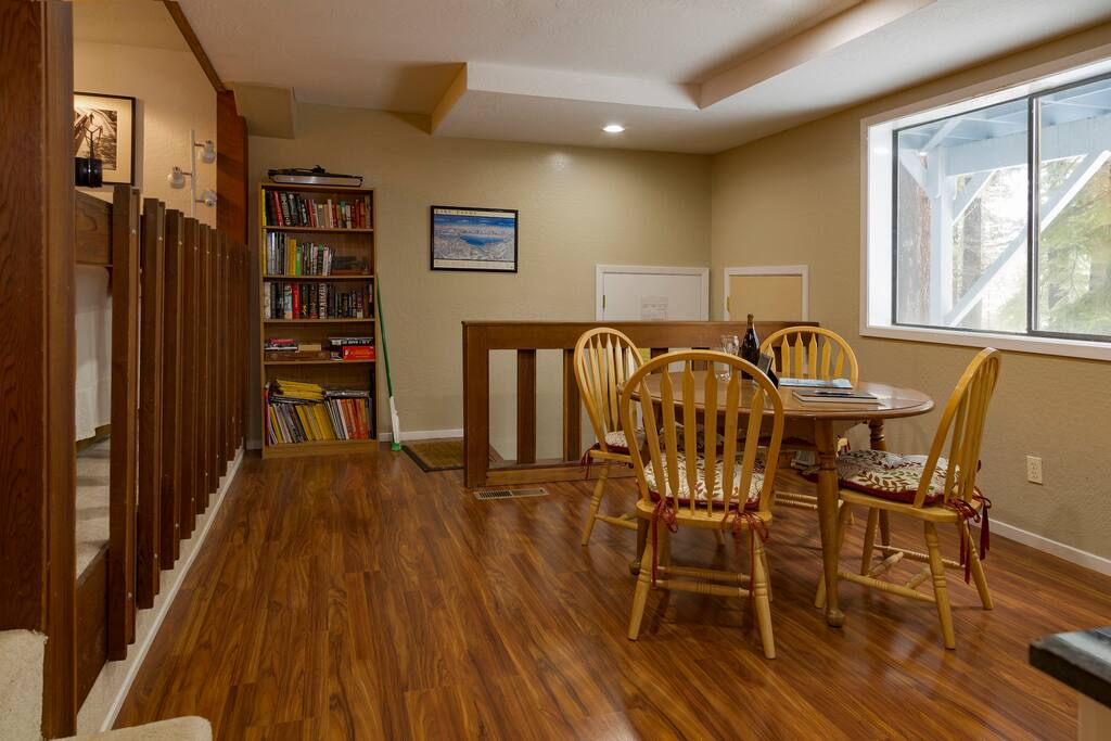 Dining area with a large window overlooking backyard and forest. Private entrance is the door on the right in the corner.