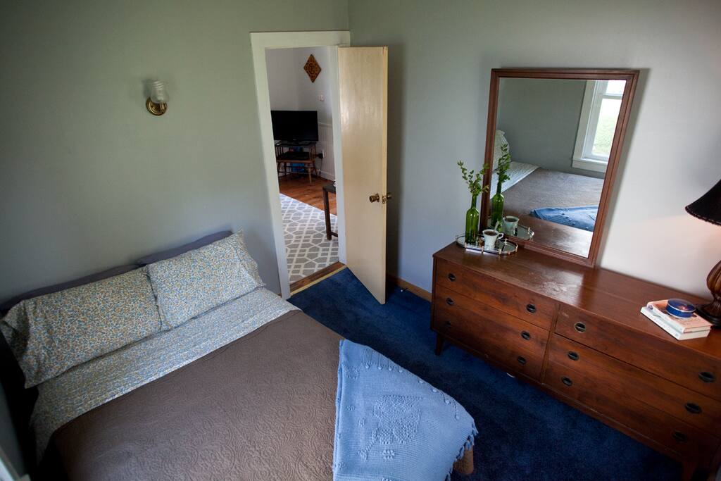 Comfy bedroom with full mattress, soft sheets and a dresser.