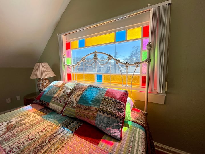 Il sole splende contro l'antica vetrata colorata nella camera da letto al piano superiore. 