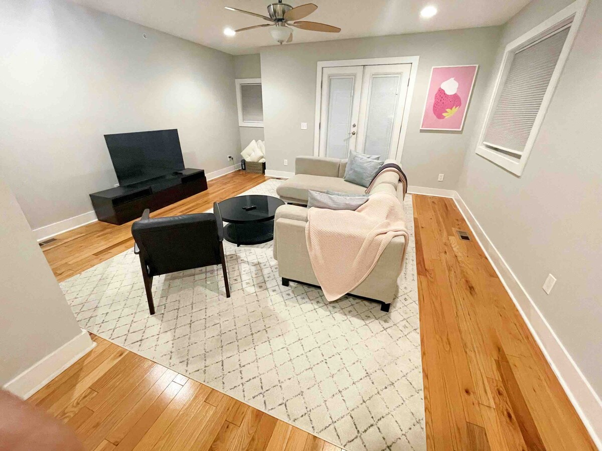 Მყუდრო მისაღები ოთახი ტელევიზორით და კომფორტული სექციური ტახტით 