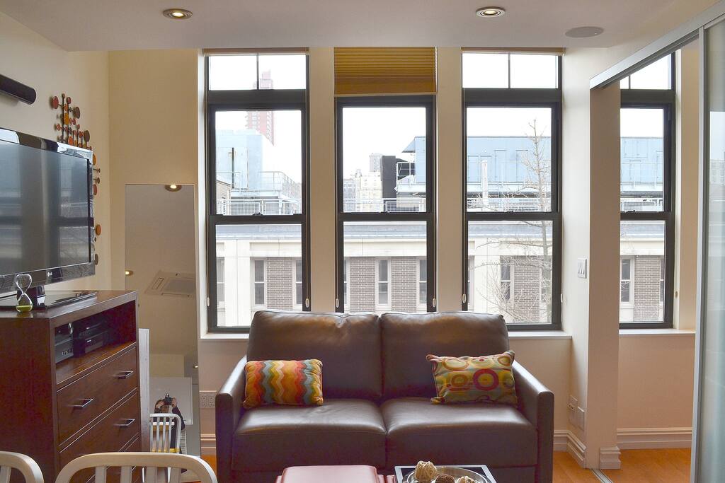 Living Room with Full Size Leather Sofa Bed, Media Chest with Home Theater System, IP TV, Playstation & Wifi
