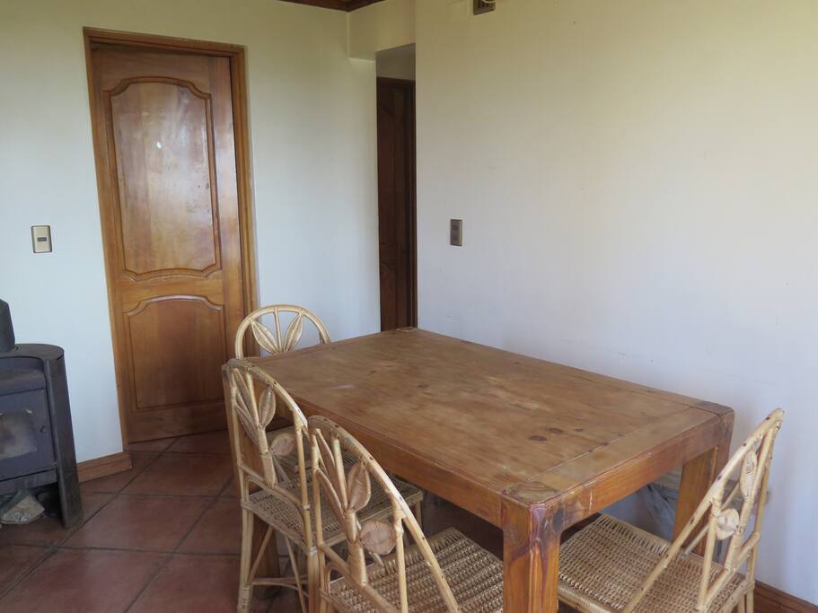 Living area with dining table and door to second bedroom.