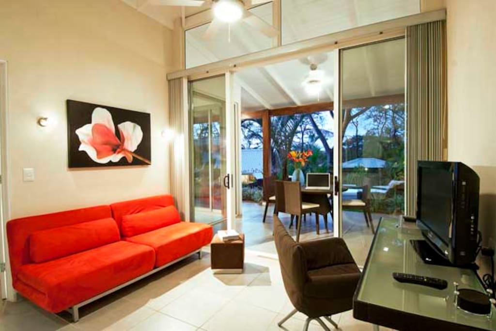 Bright living room w/ pullout couch, dining patio