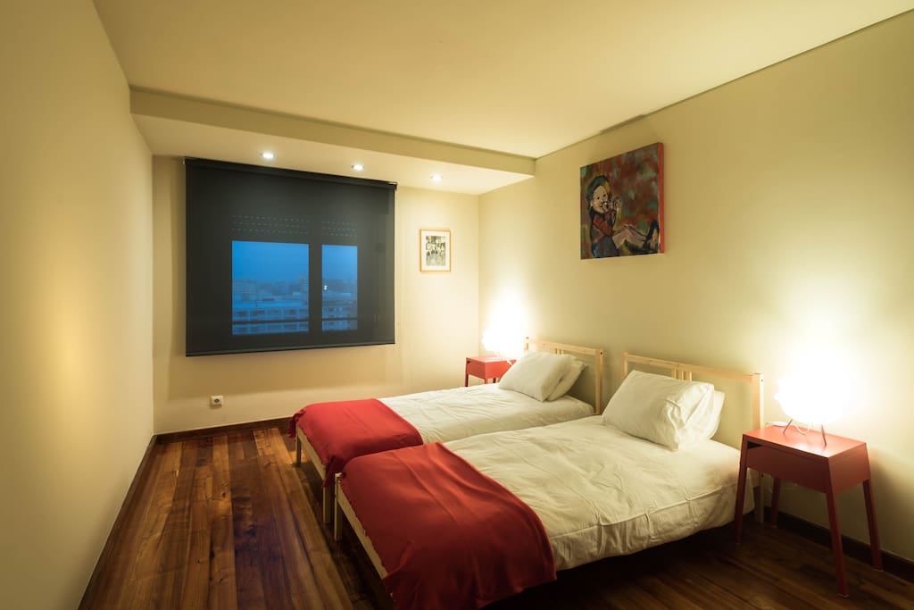 Quarto inferior com 2 camas single, guarda-roupa completo e AC.