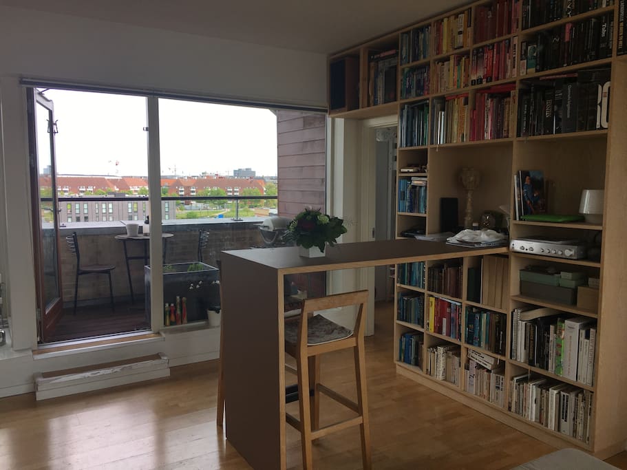 Livingroom with door to balcony and view over Nørrebro and sunrise