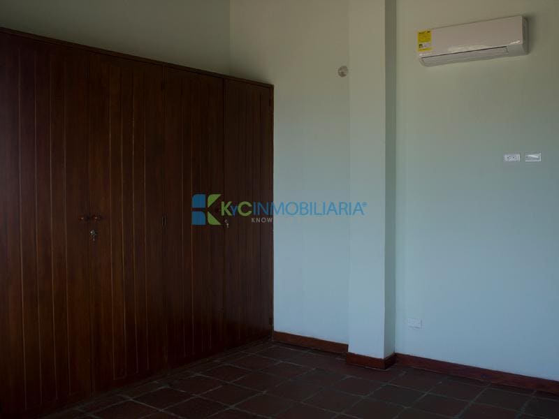 غرفة نوم رئيسية بسرير بحجم كبير وخزانة كبيرة ومكيف هواء.