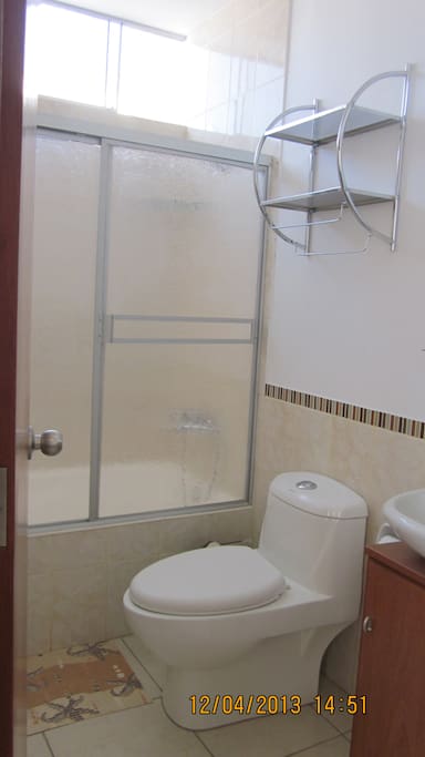 baño principal con tina, lavadero y mueble.