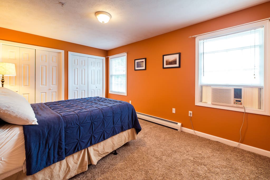 Bedroom with full-sized bed, natural light, closet space, and personal AC unit.