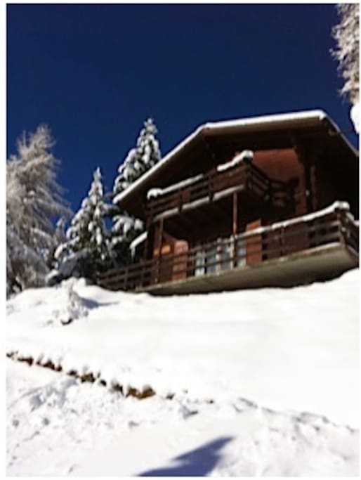 Le chalet sous la neige avec le ciel pur de l'hiver