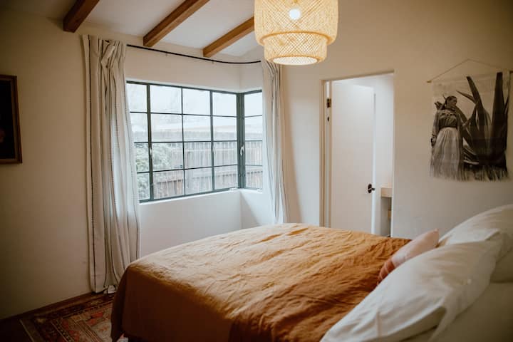 Primary bedroom with en-suite bathroom and lots of natural light. Queen bed with organic cotton linens.