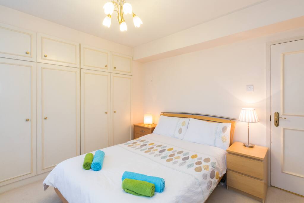 First bedroom with king size bed, lots of natural light, and plenty of storage space.