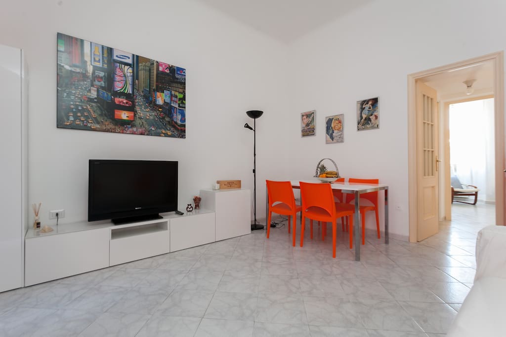 The living room: sofa, TV & the dining table