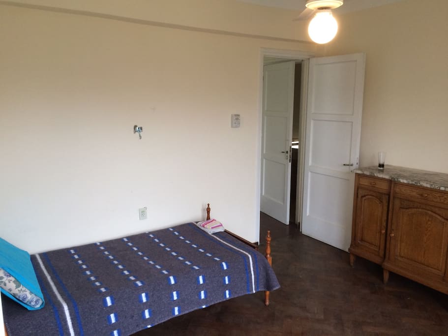 Irish Room: Single bed, closet, lounging chair, and ceiling fan.